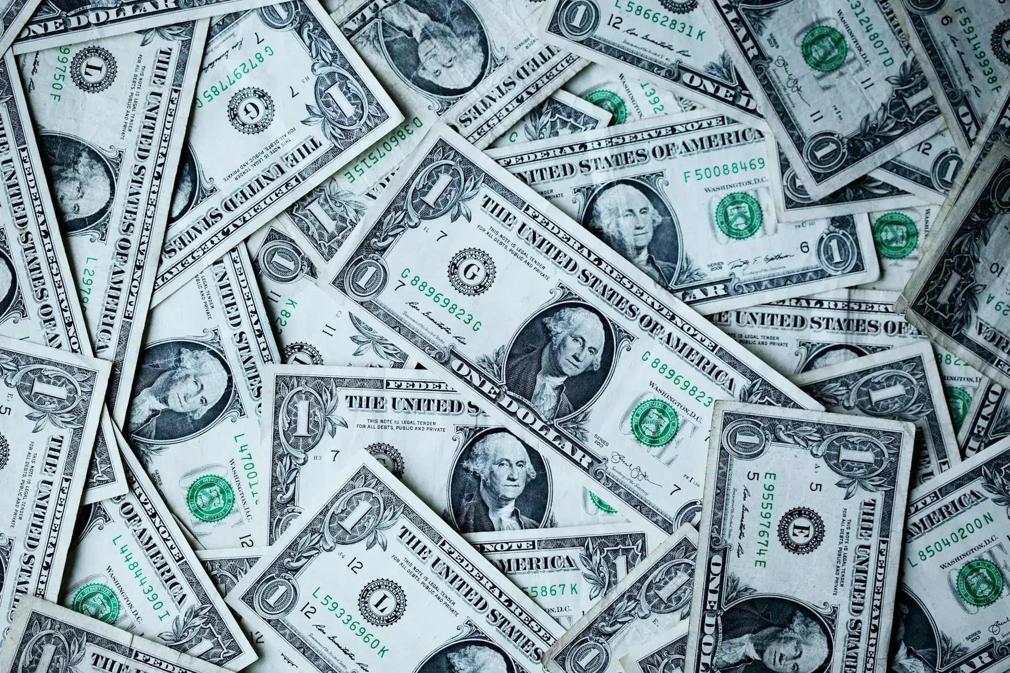 Scattered US dollar bills covering a flat surface